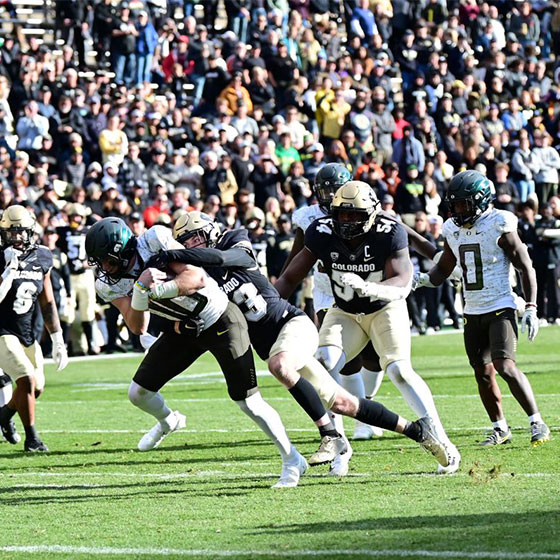 Colorado Buffaloes defender sacks Oregon quarterback in front of packed crowd at Folsom Field in Boulder.