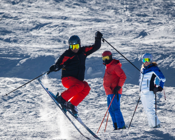 Three skiers in action skiing down a Colorado snow slope.